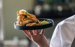 tjener står med pasfalls signatursnack.webp