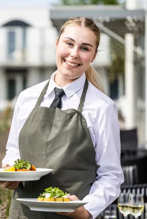 tjener smiler og står med sommer serveringer.webp