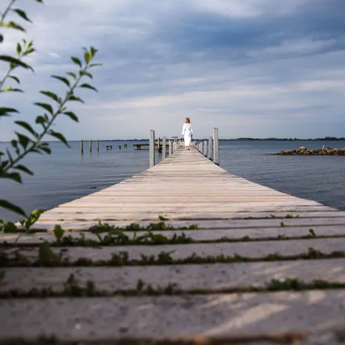 Kvinde I Mogenkåbe På Badebro