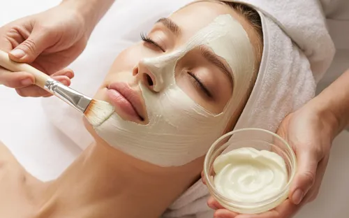 ansigtsbehandling med maske der påføres med pensel.webp